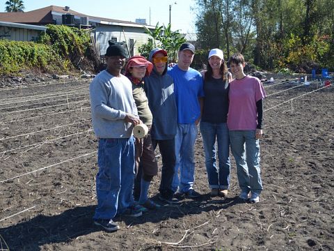 Nola Tilth founder Megan Webbeking, second from right, stands in front of her flower and vegetable garden with volunteers.